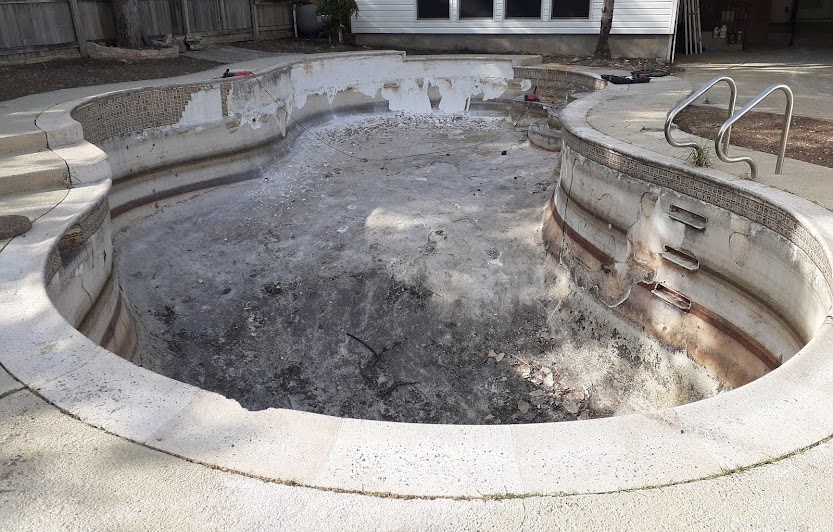 Old damaged pool surface needing repair